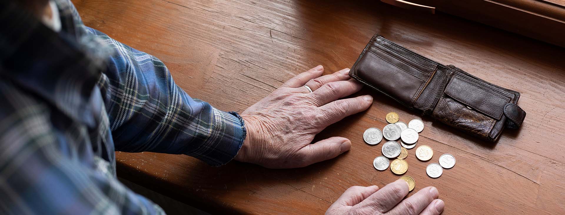 Elder man counting change from his wallet